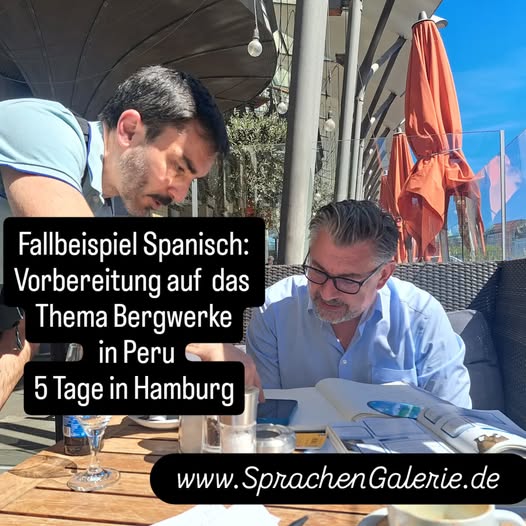 ein stehender junger Mann  einem sitzenden Mann in den Fünfzigern etwas am Handy draußen am Cafe-Tisch, wo mehrere Papiere zu sehen sind - outdoor Atmosphare im Sommer in Hamburg erkennbar