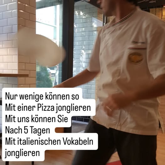 Ein Pizza-Mann jongliert mit Pizzateig im Innenraum